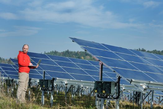 business man  engineer using laptop at solar panels plant eco energy field  in background