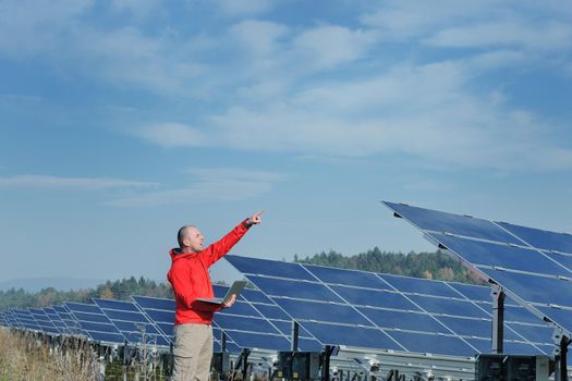 business man  engineer using laptop at solar panels plant eco energy field  in background