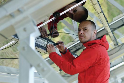 Male engineer at work place, solar panels plant industy in background