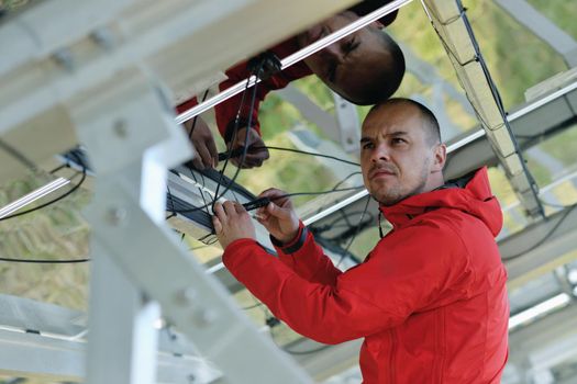 Male engineer at work place, solar panels plant industy in background