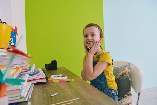 cute children portrait. Little girl smiling at home making funny face and acting