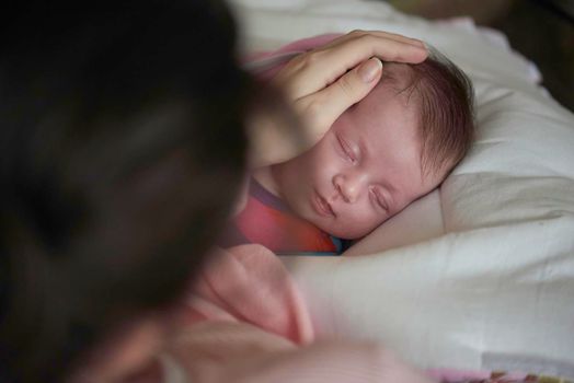 new born baby sleeping and in dreams smillling  mother care protection