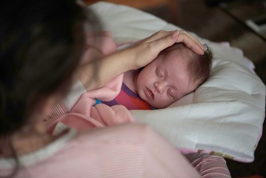 new born baby sleeping and in dreams smillling  mother care protection