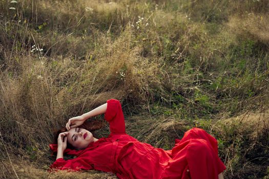 woman in a black dress lies in a field nature fashion summer. High quality photo