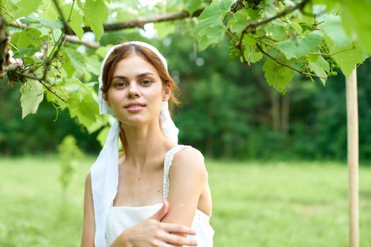 Woman in white dress in the village outdoors Green grass Farmer. High quality photo
