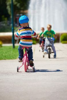 happy little boy have fun in park and learning to ride his first bike