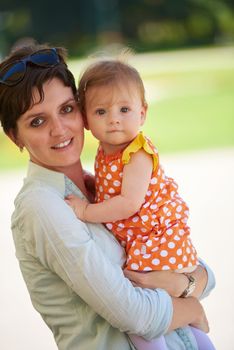 happy mother and baby child in park making first steps .  Walking and hugging.