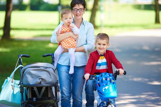 portrait of happy young family,  mother and  kids have fun in park