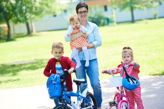 portrait of happy young family,  mother and  kids have fun in park