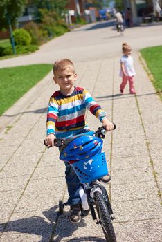 happy little boy have fun in park and learning to ride his first bike