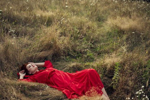 woman in a black dress lies in a field nature fashion summer. High quality photo