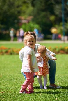 happy mother and baby child in park making first steps .  Walking and hugging.