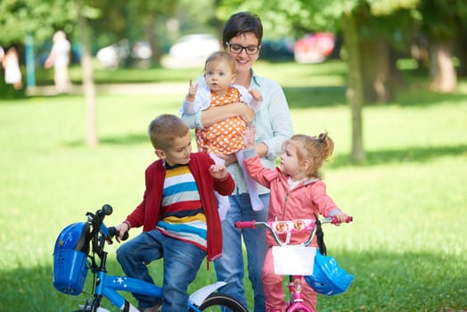 portrait of happy young family,  mother and  kids have fun in park