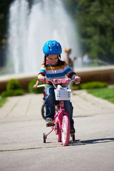 happy little boy have fun in park and learning to ride his first bike