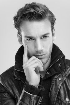 Fashion man, Handsome serious beauty male model portrait wear leather jacket, young guy over gray background