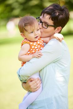 happy mother and baby child in park making first steps .  Walking and hugging.