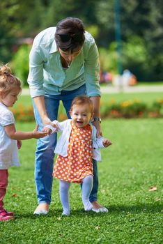 happy mother and baby child in park making first steps .  Walking and hugging.