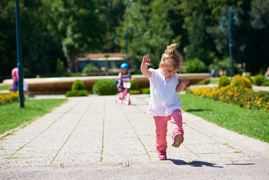 Happy childrens outdoor,  brother and sister in park have fun. Boy and girl in park learning to ride a bike.