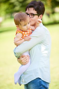 happy mother and baby child in park making first steps .  Walking and hugging.