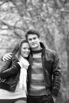 Happy young Couple in Autumn Park. Fall. Yellow Trees and Leaves. Laughing Man and Woman outside. Freedom Concept.