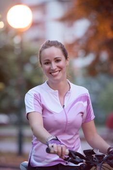 portrait of sporty happy woman with bike in park,  taking brake and relaxing after exercise