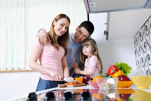 happy young family have lunch time with fresh fruits and vegetable food in bright kitchen 