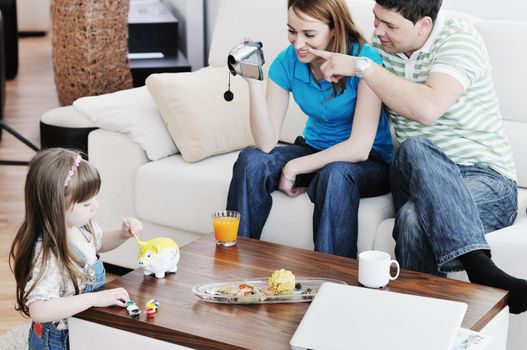 young happy family recording by video camera their child at home