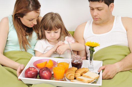 happy young family eat breakfast in bed at morning