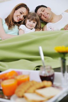 happy young family eat breakfast in bed at morning