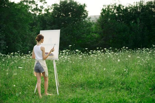 woman artist in aprons paint palette easel nature. High quality photo