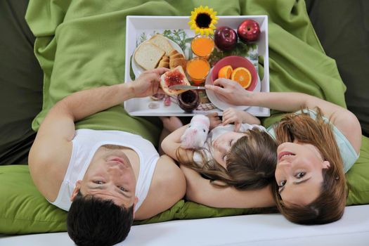 happy young family eat breakfast in bed at morning