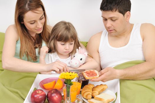 happy young family eat breakfast in bed at morning