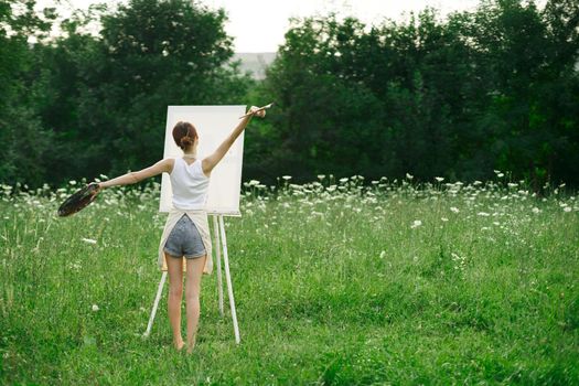 artist in nature painting a picture creative landscape back view. High quality photo