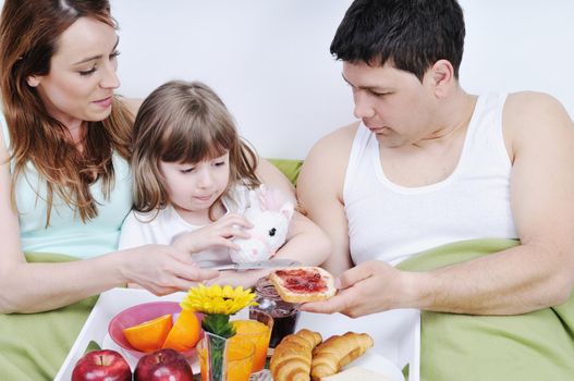 happy young family eat breakfast in bed at morning 