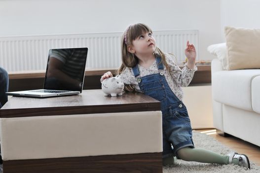 happy young girl  portrait at home while painting piggy bank and representing banking and finance concept