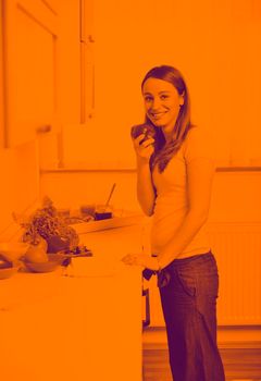 happy young  woman with apple in kitchen and other food and vegetables duo tone