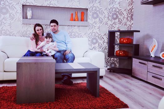 happy youg family relaxing in modern livingroom at home