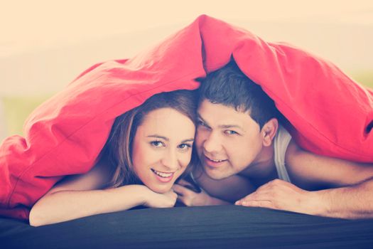 happy young couple in bed at morning