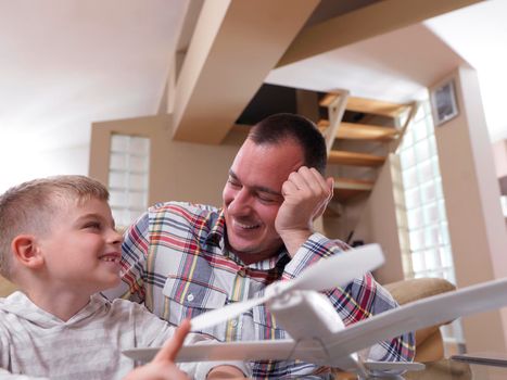 father and son assembling airplane toy at modern home living room indoor