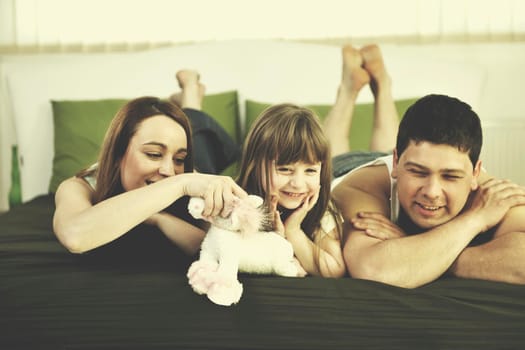 happy young family relaxing in bed 