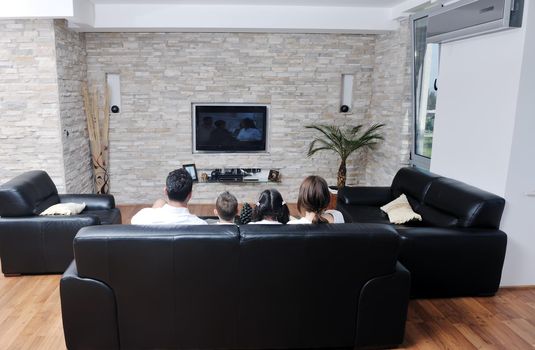 happy young family wathching flat tv at modern home indoor