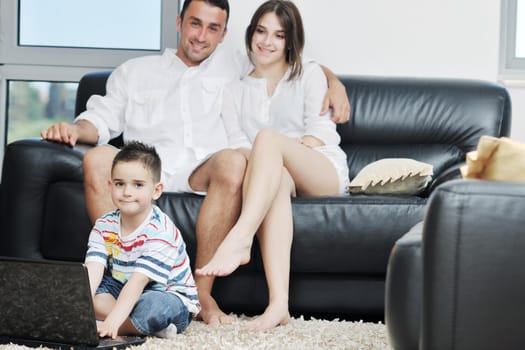 happy young family have fun and working on laptop at modern  home livingroom indoor