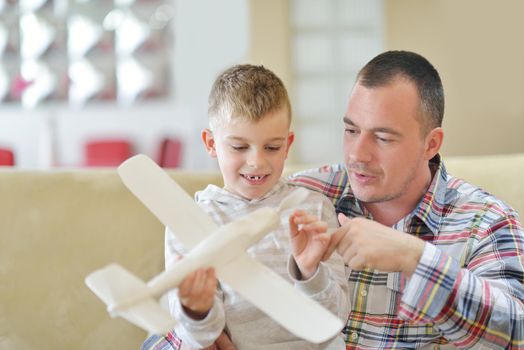 father and son assembling airplane toy at modern home living room indoor