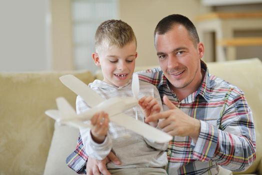 father and son assembling airplane toy at modern home living room indoor