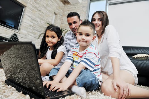 happy young family have fun and working on laptop at modern  home livingroom indoor