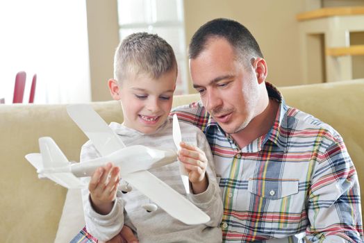 father and son assembling airplane toy at modern home living room indoor