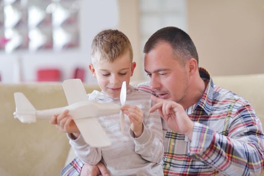 father and son assembling airplane toy at modern home living room indoor