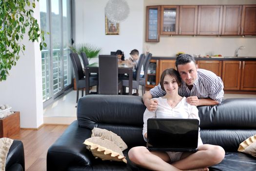 happy young family have fun and working on laptop at modern  home livingroom indoor