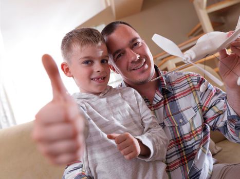 father and son assembling airplane toy at modern home living room indoor