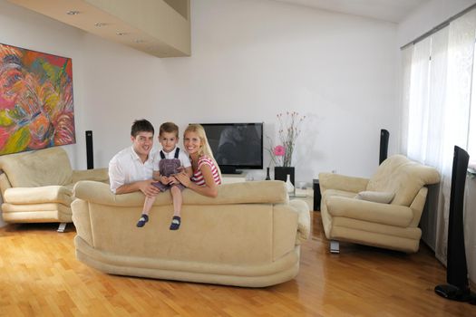 happy young family with kids in bright modern living room have fun and looking big flat lcd tv